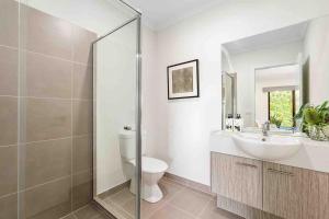 a bathroom with a sink and a toilet and a shower at Lavish Modern Home - 10mins to Torquay & Geelong in Mount Duneed