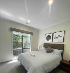 a bedroom with a large bed and a window at Lavish Modern Home - 10mins to Torquay & Geelong in Mount Duneed