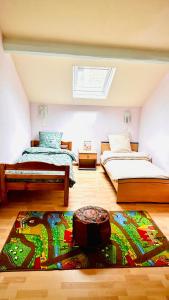 a bedroom with two beds and a rug on the floor at Évasion Familiale à Essises - Proche des vignobles in Essises