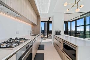 パースにあるBright & Spacious 2BR in Prime CBD Locationのキッチン(コンロ付)が備わります。一部の窓が付いています。