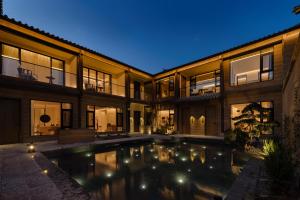DiannanShaxi Fengyasong Village Hotel的带游泳池的房屋外观