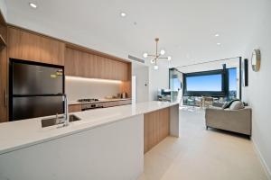 パースにある1BR Apartment in the Heart of the CBDのキッチン(大きな白いカウンタートップ、ソファ付)