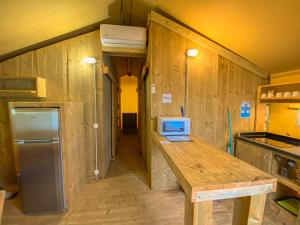 a kitchen with wooden walls and a counter with a refrigerator at Càmping Parc Gualba in gualba de Dalt
