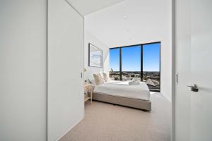 パースにある1BR Apartment in the Heart of the CBDのベッドと大きな窓のある寝室