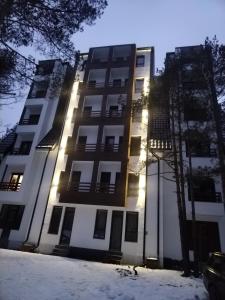 Un edificio con il sole che splende sulla neve di Divcibarski izvor a Divčibare