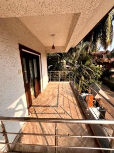 Un balcón de un edificio con una puerta y una palmera. en Nikita Retreat Stay, en Calangute