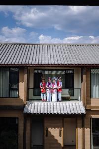 un grupo de personas de pie en la parte superior de un edificio en Shaxi Fengyasong Village Hotel, en Diannan