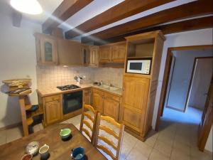 a kitchen with wooden cabinets and a wooden table at Le Mazet de la Régordane in Saint-André-Capcèze