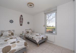 a bedroom with two beds and a window at Lumaïa - Vue cité, terrasse & Piscine in Carcassonne +7 photos