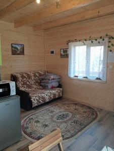 a log cabin with a bed and a window at Cabana Ulmului in Vişeu de Sus +21 photos