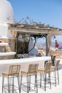 a group of chairs sitting around a table at Luxury villa with stunning views above Kalo Livadi in Mýkonos City