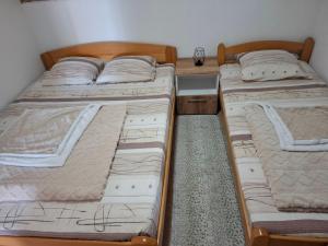 three beds sitting in a room with at Apartman DADO in Mrčevac