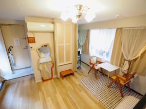 ein Wohnzimmer mit einem Tisch, Stühlen und einem Schreibtisch in der Unterkunft UENO 704 jellynehouse in Tokio