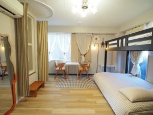 ein Schlafzimmer mit einem Bett, einem Tisch und Stühlen in der Unterkunft UENO 704 jellynehouse in Tokio