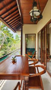 a dining room with a wooden table and chairs at Sapodilla Ubud in Ubud
