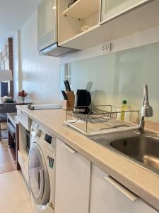 a kitchen with a washing machine and a sink at 清迈市区Astra condo 屋顶无边泳池可步行至夜市 in Chiang Mai
