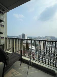 a balcony with a chair and a view of the city at 清迈市区Astra condo 屋顶无边泳池可步行至夜市 in Chiang Mai