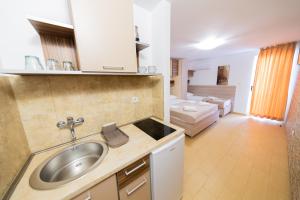 a kitchen with a sink and a living room at Azzuro apartments Budva in Budva +96 photos
