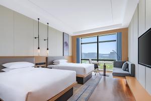 a hotel room with two beds and a flat screen tv at Fairfield by Marriott Beijing Daxing Airport in Beijing