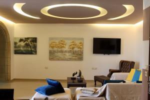a living room with couches and a tv on a ceiling at Villa Moné in Koskinou