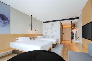 two beds in a hotel room with a tv at Fairfield by Marriott Beijing Daxing Airport in Beijing