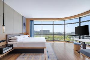 a hotel room with a bed and a large window at Fairfield by Marriott Beijing Daxing Airport in Beijing