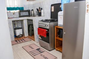 a kitchen with a stove and a refrigerator at Relax in this Karatina,Nyeri comfy, Quiet and stylish apartment in Karatina