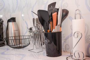 a black container filled with utensils on a counter at Relax in this Karatina,Nyeri comfy, Quiet and stylish apartment in Karatina +6 photos