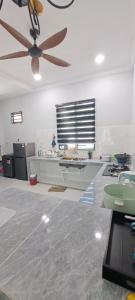 Bukit PayongにあるRaudhah Homestay Tasek Kuala Terengganuのキッチン(天井ファン、カウンター付)
