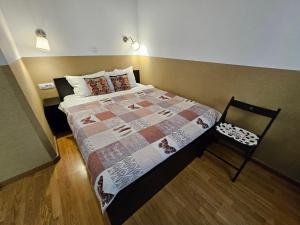 a small bedroom with a bed and a chair at Casa Mario in Sibiu