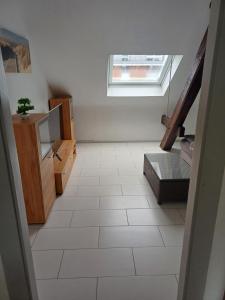 a room with a white tile floor and a window at Skylight46 La Terrasse St Louis in Saint-Louis