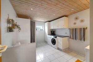 a kitchen with a washer and dryer in a room at Like Home Holiday House 9 B in Varde +14 photos