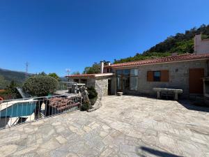 a house with a patio with a bench on it at Casa da Lage - Vistas rio - Gerês - Lareiras in Geres