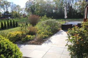 a garden with a stone walkway and plants at Ferienhaus Weideblick in Hymendorf