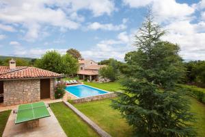 a backyard with a swimming pool and a house at Villa Favola, a rustic retreat surrounded by beautiful nature in Vinež