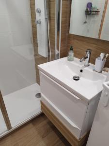 a bathroom with a white sink and a shower at Lilalune in La Grande-Motte