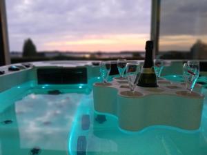 a bottle of wine sitting on a table with wine glasses at natura in Sallenelles