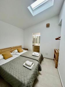 a bedroom with two beds and a skylight at VILLA MAR in Cala'n Bosch