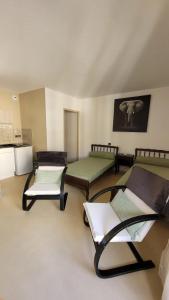 a room with three beds and chairs in it at Appartement BARBOTAN LES THERMES in Cazaubon