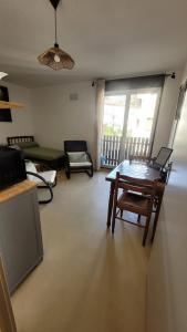 a living room with a table and a couch at Appartement BARBOTAN LES THERMES in Cazaubon