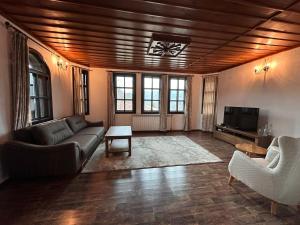 a living room with a couch and a tv at Бутиков хотел "Родопски Легенди" in Vrata