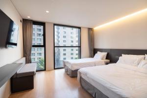 a hotel room with two beds and a flat screen tv at Celib Yeoui in Seoul