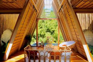 a room with a large window and a table and a tub at บ้านธารหมอก แอท สะปัน in Ban Huai Ti