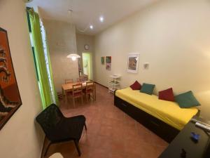 una camera da letto con due letti, un tavolo e una sedia di Casa Angelica a Siracusa