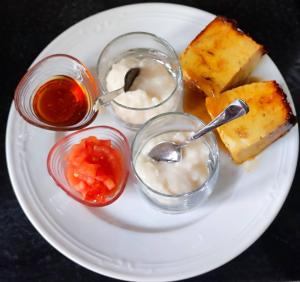 a plate of food with desserts and dipping sauce at Casa BRAIS in Barreiros