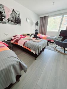 sypialnia z dwoma łóżkami i krzesłem w obiekcie Apartment in the heart of Tampere - free parking - free wifi w mieście Tampere