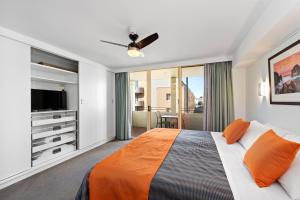Un dormitorio con una cama y un televisor de pantalla plana. en Jenatt Apartments Salamanca, en Hobart