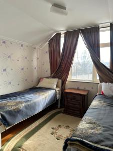 a bedroom with two beds and a window at Аренда Дома in Karakol +10 photos