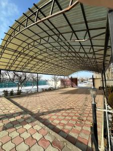 awning over a patio with a brick sidewalk at Аренда Дома in Karakol