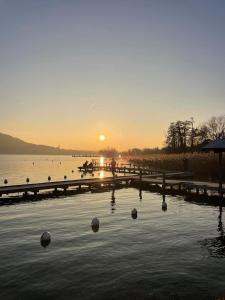 a sunset over a lake with balls in the water at La petite Venise des Alpes, Ultra centre 1 à 5 Pers in Annecy +27 photos